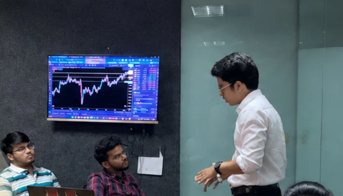 Mentor explaining chart behaviour to students during a trading session